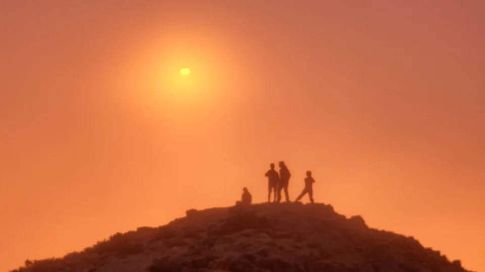 Scouts on a hilltop at sunset